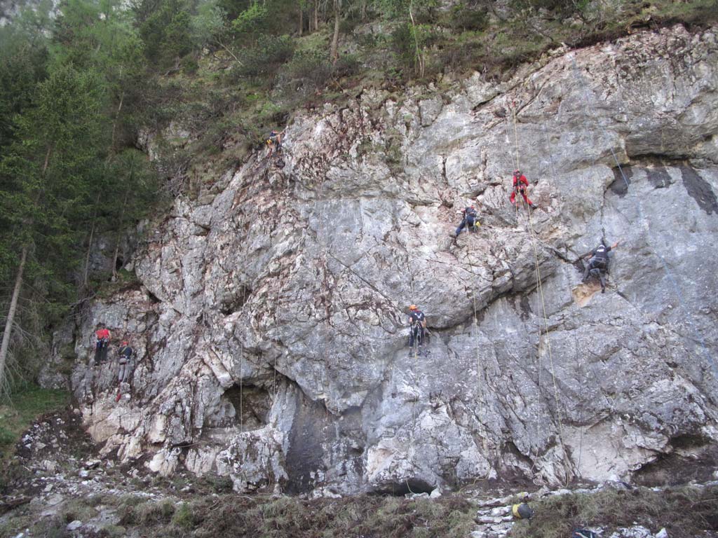 Das Bild zeigt wie Einboihr Kurse bei bolting.eu ablaufen können. Es hängen sechs Kletterer arbeitend in ineiner grauen Felswand. Man erkennt dass sie alle am Arbeiten sind und der Fels hergerichtet wird.