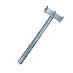 Das Bild zeigt einen silbernen Klettersteig Endanker Edelstahl. Der T-förmige Anker liegt schräg in Bildmitte. Man erkennt den Bewehrungsstahl sowie die drei Klemmen am Kopf für das Stahlseil.