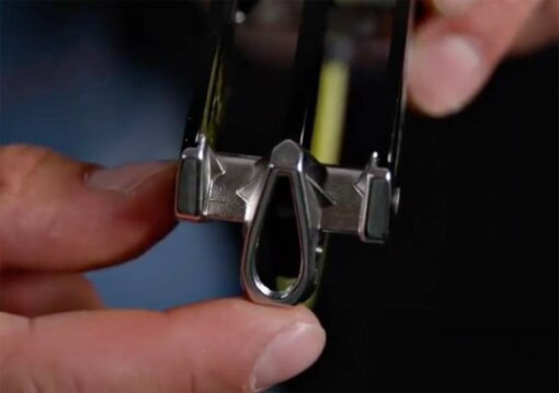 Das Bild zeigt das Edelrid Giga Jul Sicherungsgerät in einer Hand. Man erkennt die Rillen des Seilauslasses aus Edelstahl.