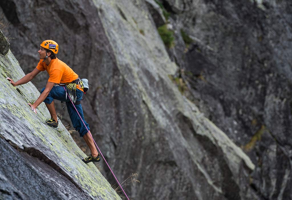 Das Bild zeigt ein Beispiel für perfekte Content Gestaltung. Ein Kletterer in auffälligem orangen Shirt klettert auf einer Felsplatte. Es soll zeigen, wie dynamisch junge Kletter Zielgruppen angesprochen werden sollen.
