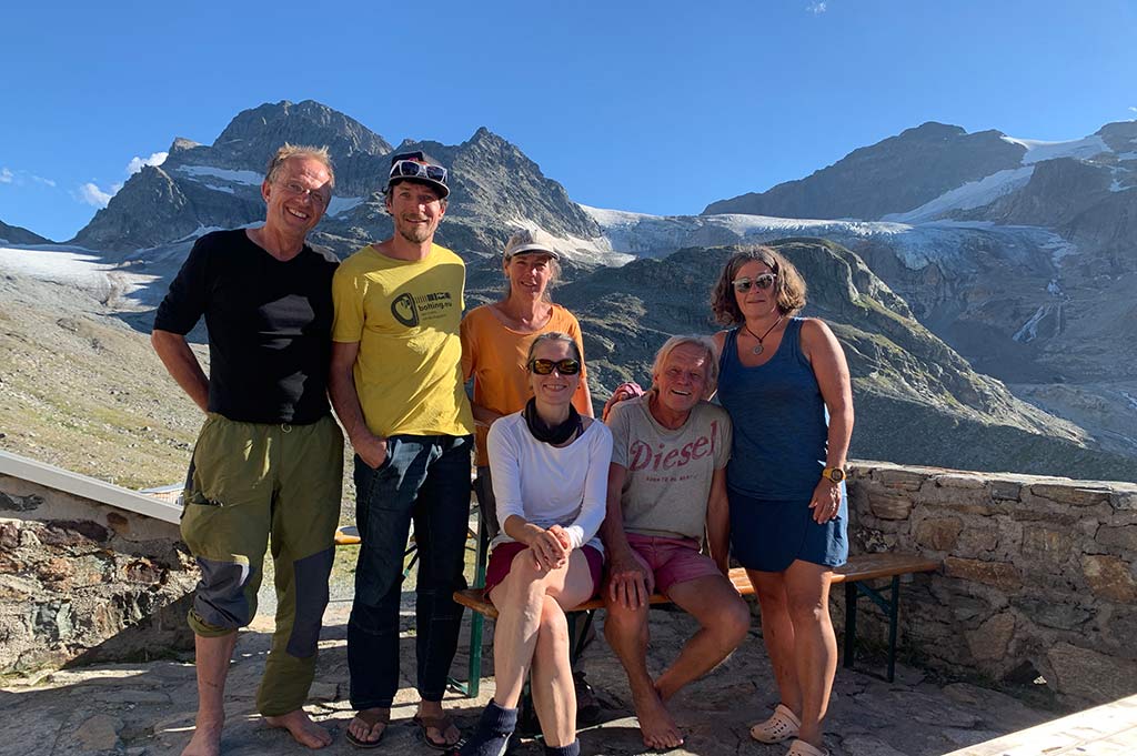 Das Bild zeigt eine Gruppe an Leuten auf der Terrasse einer Schutzhütte in der Silvretta Gruppe.