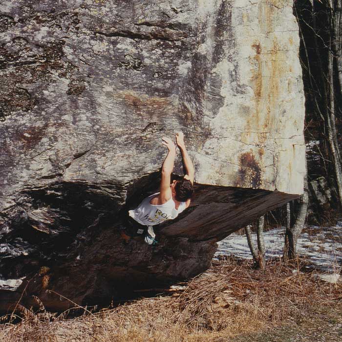 Das Bild zeigt einen Boulderer beim Klettern auf einen Granitblock im Jahre 1995 mit einem selbtsgemachten Boulder Chalkbag um die Hüfte.