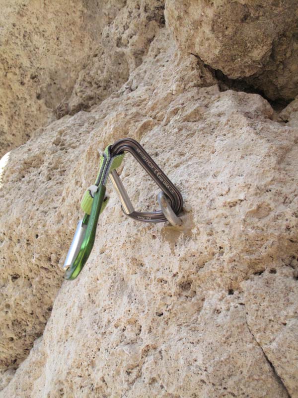 Das Bild zeigt einen Klebehaken im weißem Fels, an dem sich eine Expressschlinge verhakt hat.