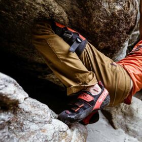 Das Bild zeigt einen Boulderer der sein Knie mit einem Knee PAd Red Chili Kneerock zwischen dem Felsen einklemmt.