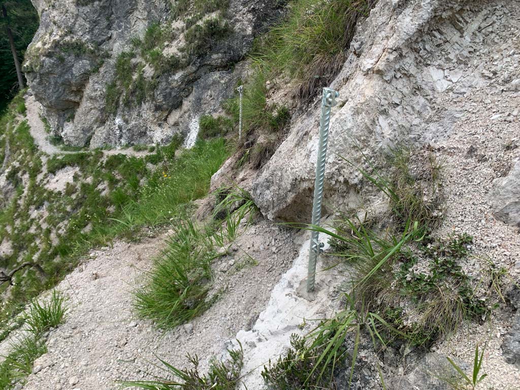 Das Bild zeigt silberne Geländestangen eingeklabt an einem steilem Geländeabschnitt.