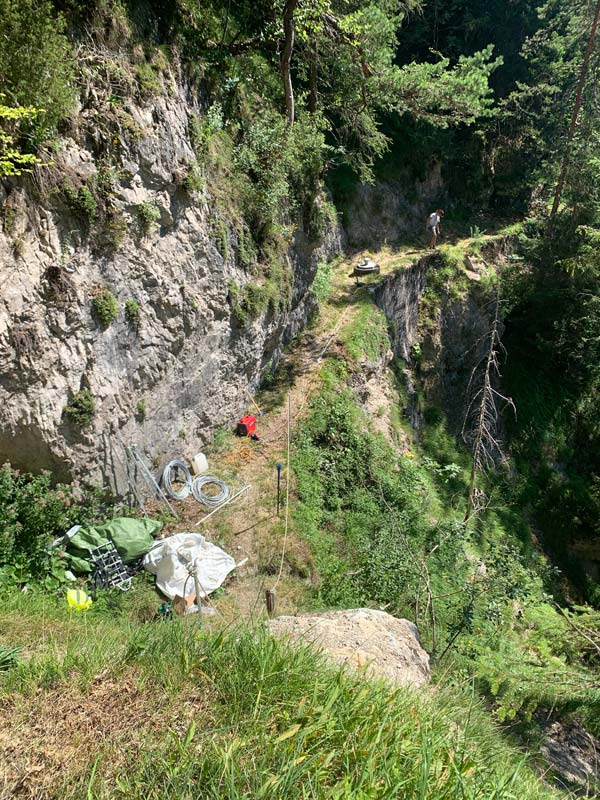 Das Beild zeigt eine BAustelle beim alpinen Wegebau neben einer Felswand.