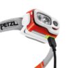 Weiß orange Petzl Stirnlampe mit Micro USB Anschluss beim Laden.