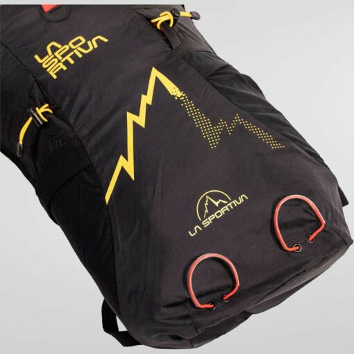 Detailaufnahme des schwarzen La Sportiva Alpine Backpack mit gelbem Logo und roten Bändern.