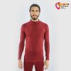 Mann in weinrotem Black Yak Herren Gurla Merino Baselayer Longsleeve von vorne.