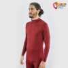 Mann in weinrotem Black Yak Herren Gurla Merino Baselayer Longsleeve von schräg seitlich.