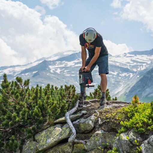 Arbeiter beim Alpinen Wegbau mit Fischer Meissel 25mm SDS Max auf einem Bohrhammer.