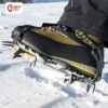 Brauner Bergschuh mit dem Grivel G1 Steigeisen angeschnallt vor Schneehintergrund.
