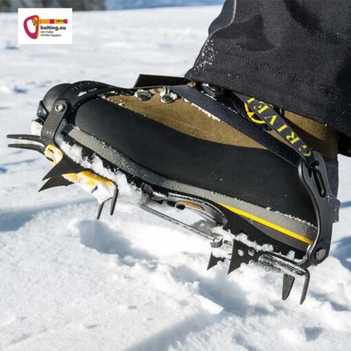 Brauner Bergschuh mit dem Grivel G1 Steigeisen angeschnallt vor Schneehintergrund.