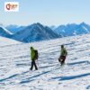 Bergsteiger auf einer Hochtour mit Gipfeln und Himmel im Hintergrund.