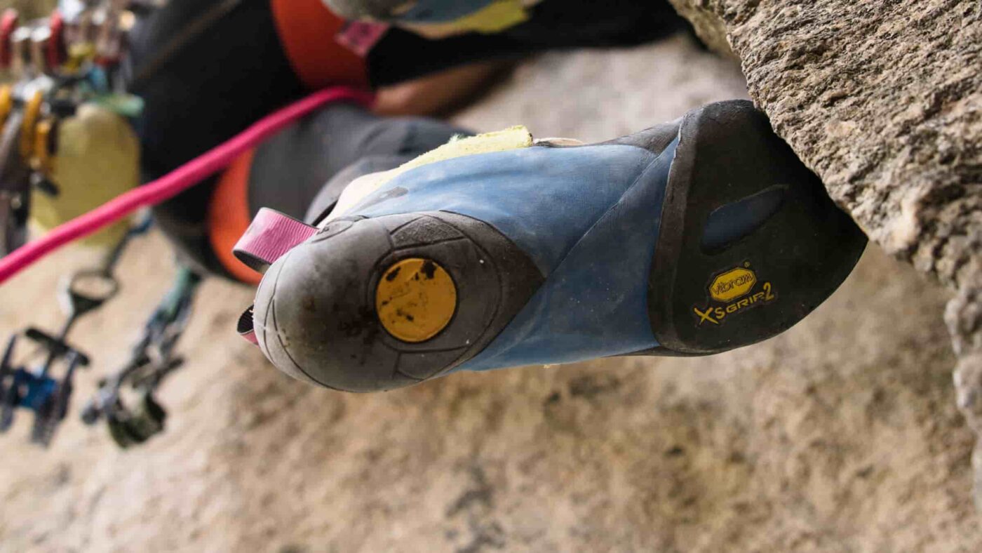 Kletterschuh mit Vibram XS Grip 2 Gummi auf Felswand..