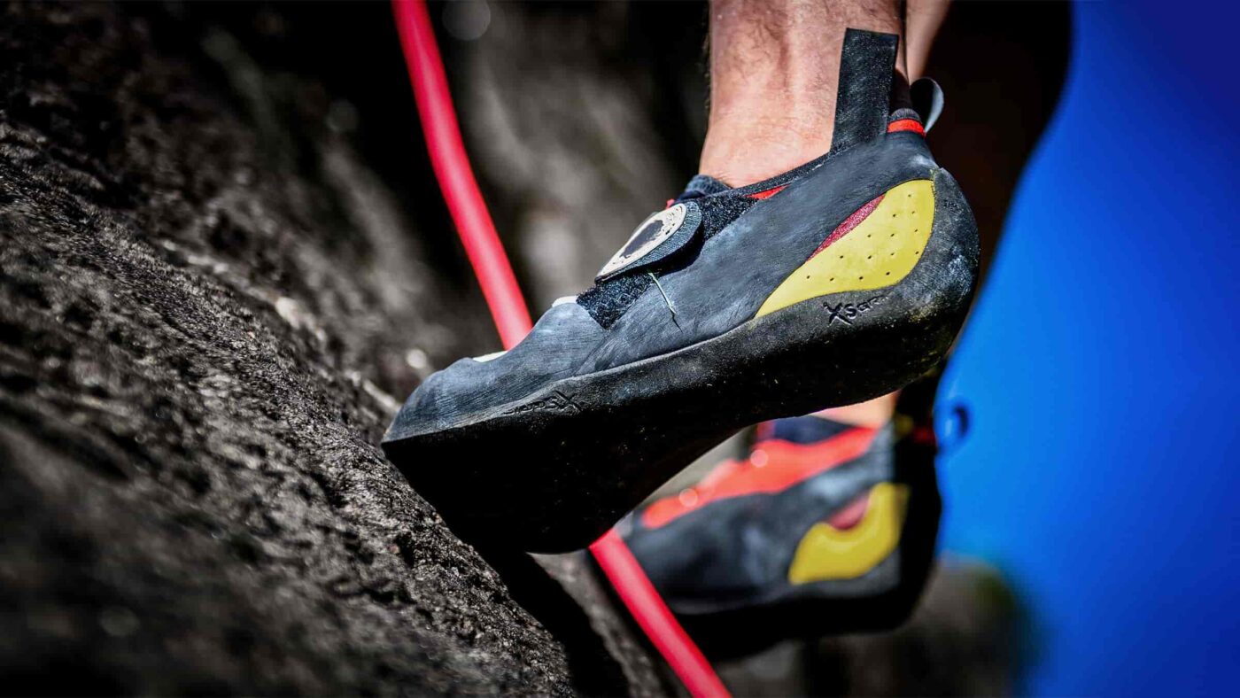 Kletterschuh mit Vibram XS Grip Gummi auf einer dunklen Felsplatte.