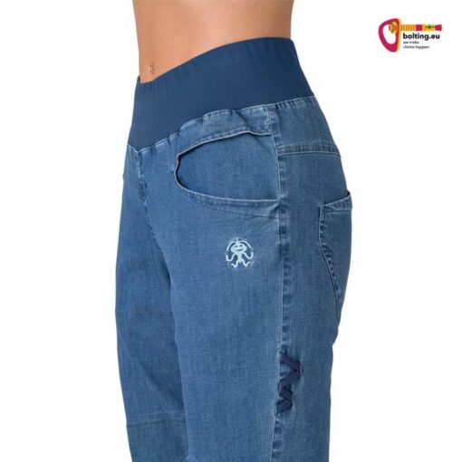 Hüftbund einer blauen Damen Jeans Kletterhose mit elastischem Stoff und Bauch einer Klettererin.