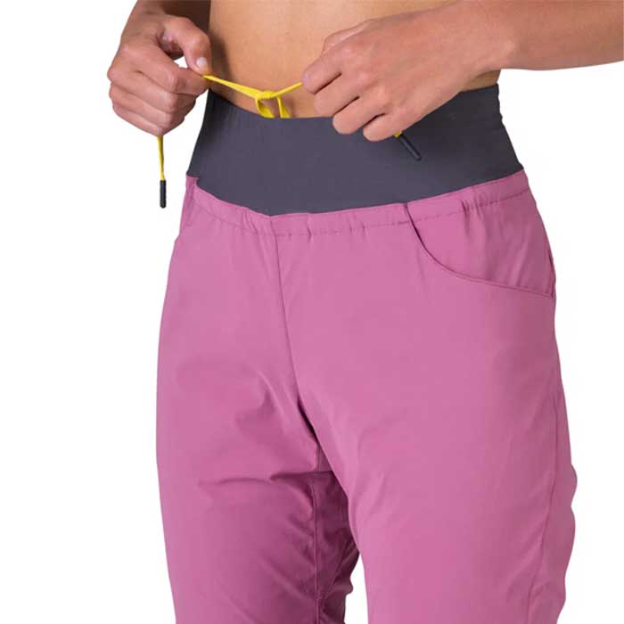 Bauchfreies Modell mit Rafiki Femio Kletterhose und gelbem Kordelzug in der Hand.