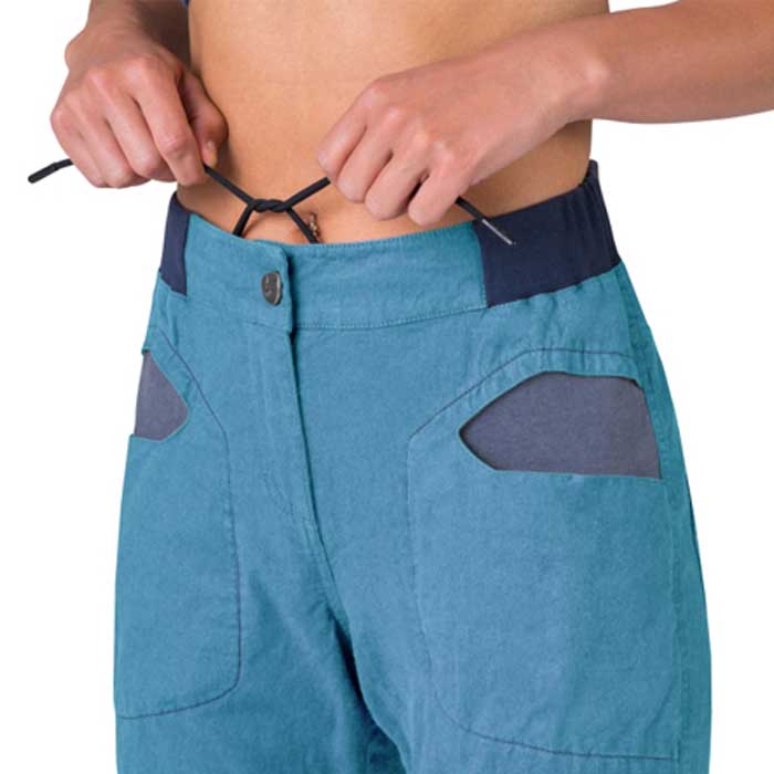 Modell ohne Shirt beim Zuknöpfen einer Kordel an hellblauer Rafiki Shiva Damen Leinen Kletterhose.