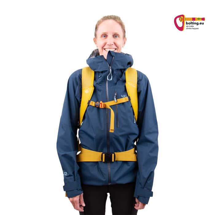 Modell in blauer Jacke mit gelbem Kohla Alpinist 22 Kletterrucksack von der Vorderseite.