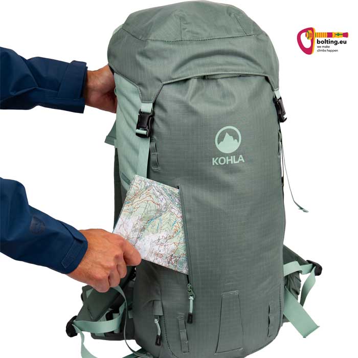Hand steckt Wanderkarte in die Seitentasche eines lavendelfarbenem Kohla Alpinrucksack.