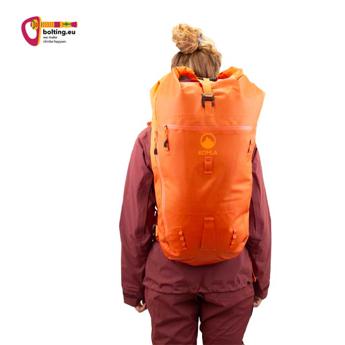 Modell mit lila Bekleidung und orangem Kohla Alpinist Pro 32 Rucksack.
