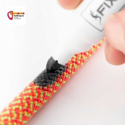 Hand mit schwarzem Stift beim Anbringen einer Seilmarkierung auf orangem Seil.