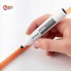 Hand mit schwarzem Stift beim Anbringen einer Seilmarkierung auf orangem Seil.