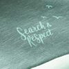 Details eines Chillaz Damen Kapuzenpullis mit "Search and Respect" Schriftzug auf grünem Stoff.