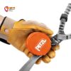 Hand mit Kletterhandschuhen hält einen orangen Petzl Bandfalldämpfer ein.