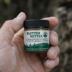 Eine HAnd hält ein Gläschen mit Kletterretter repair Balm mit Schriftzug.